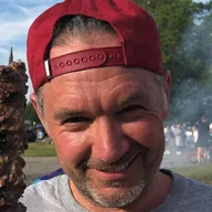 A customer at a county fair holding two beef skewers (illustrative photo)
